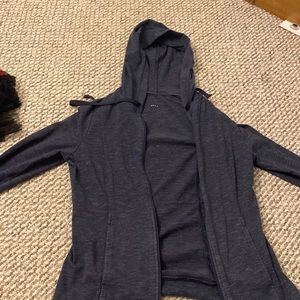 dark navy hoodie, snug sleeves.
